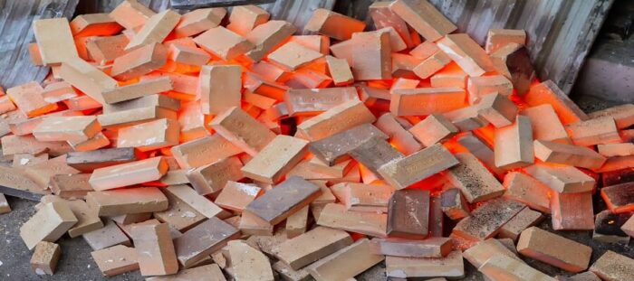 Multiple red hot refractory bricks after they have been used and discarded